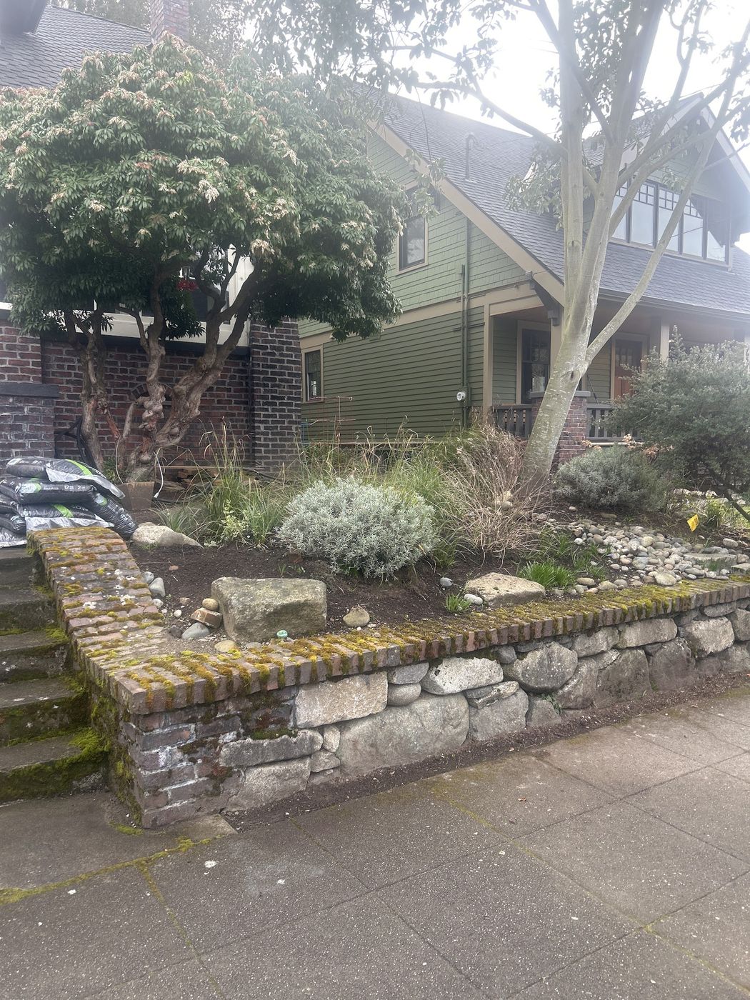 Mulched front planting bed above a stone retaining wall